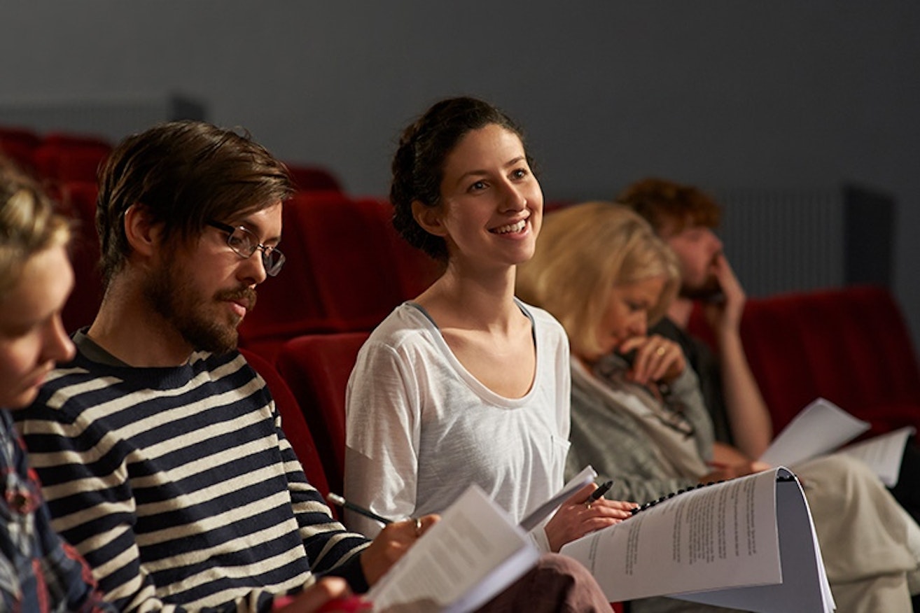 Actors sitting in theatre with scripts 750x500