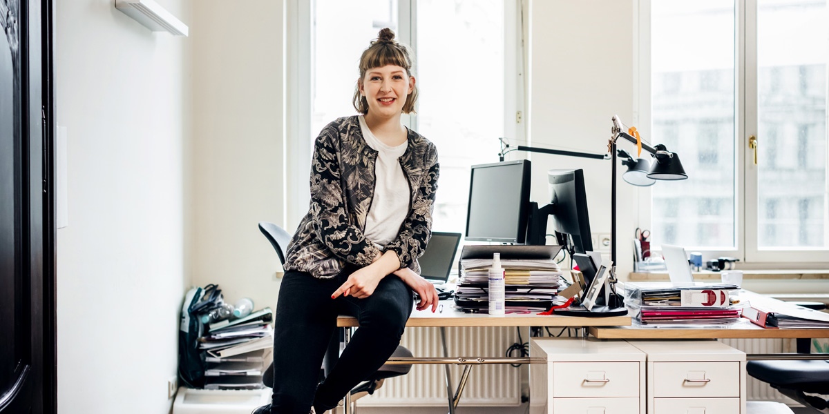 Girl sitting on desk 1200x600