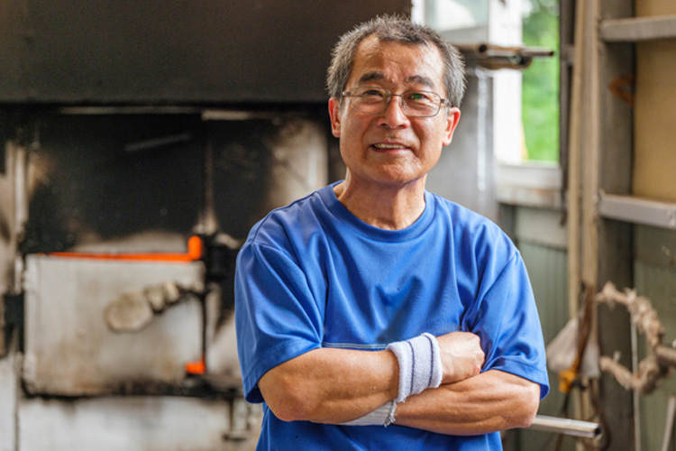 Man smiling at camera with arms folded 750x500